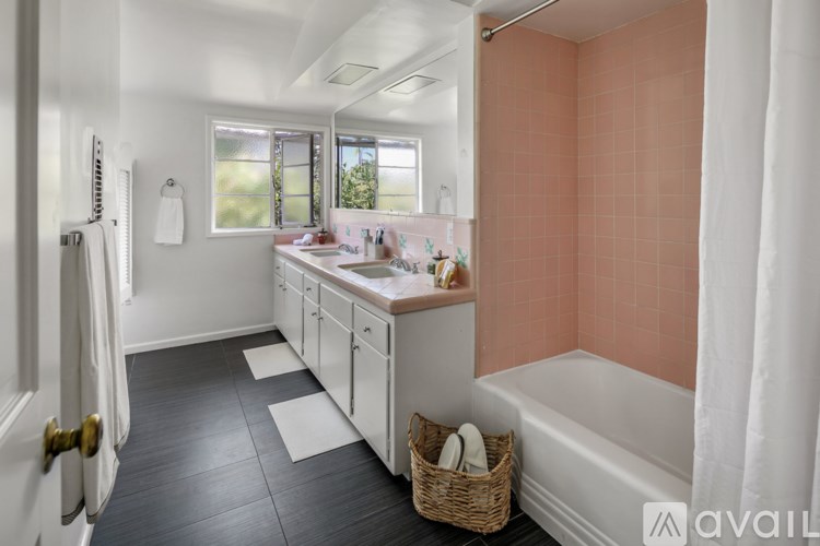 A bathroom with a tub, sink, and a window.