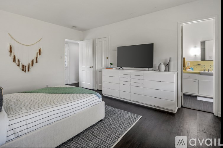 A bedroom with a bed, dresser, and mirror.