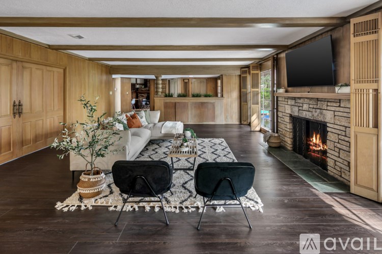 A living room with a fireplace and two chairs.