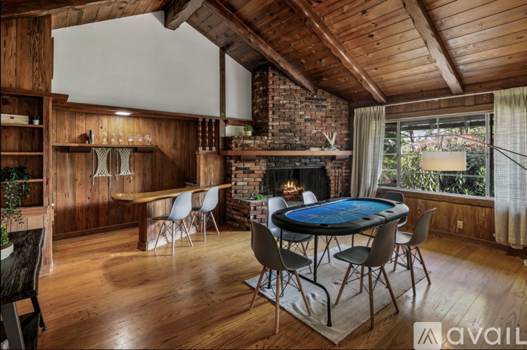 A wooden room with a poker table and chairs.
