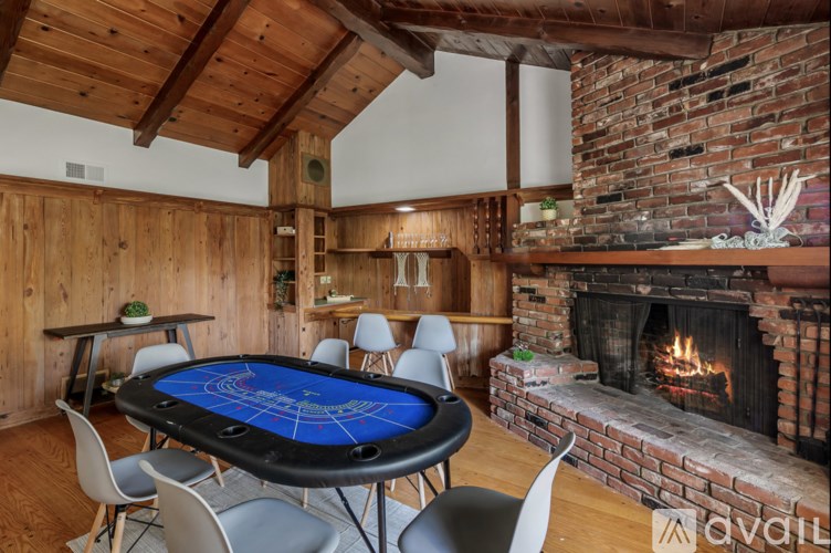 A poker table is set up in a room with a brick fireplace.
