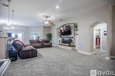 A living room with a grey carpet and a brown sofa.