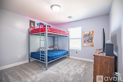 A bedroom with a bunk bed and a television.