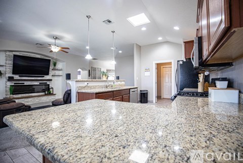 A kitchen with granite countertops and a large island in the center.