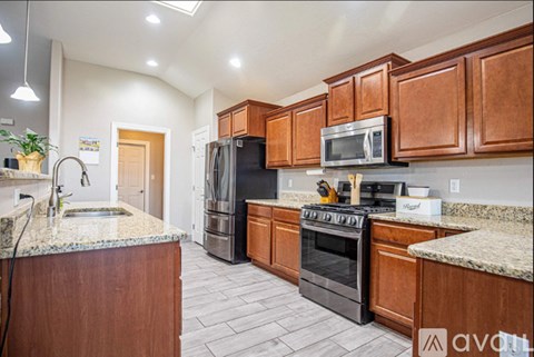 A kitchen with wooden cabinets and granite countertops.