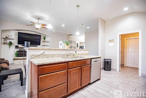 A kitchen with a marble countertop and wooden cabinets.