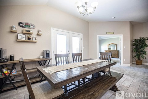 A dining room with a wooden table and chairs.