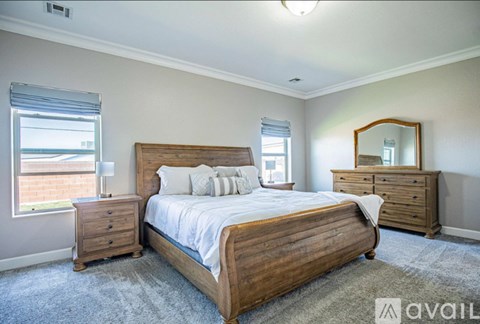 A bedroom with a large bed, a dresser, and a mirror.