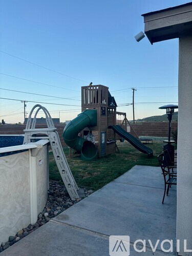 A playground with a green slide and a white slide.