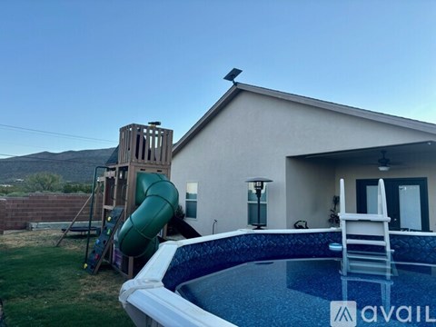 A house with a pool and a slide in the backyard.