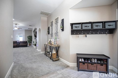 A hallway with a bench and a table with shoes on it.