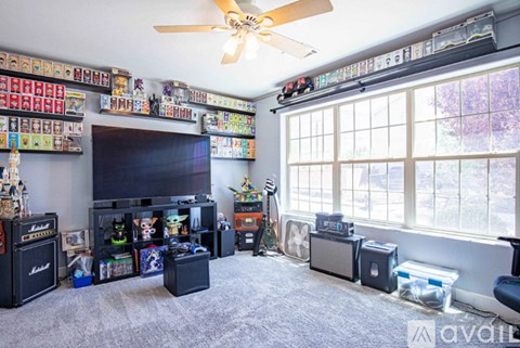 A room with a ceiling fan and a large window.