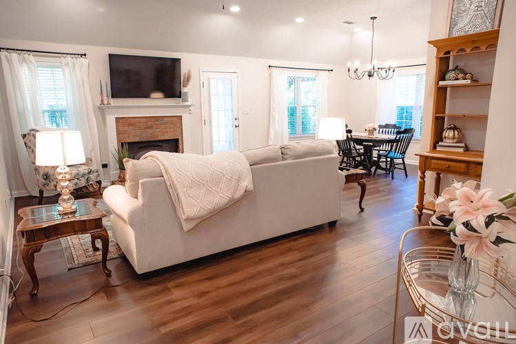 A living room with a white couch and a fireplace.