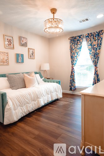 A bedroom with a white bed and a chandelier.