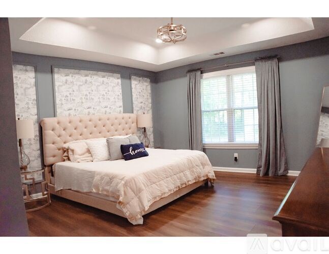 A bedroom with a large bed and a chandelier.