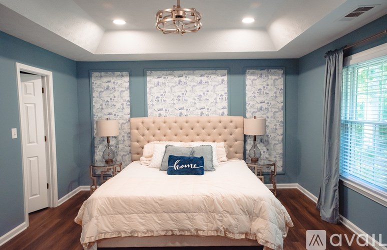 A bedroom with a white bed and a chandelier.