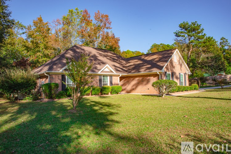 A house with a brown roof and a tree in front of it.