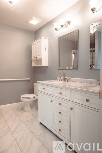 A bathroom with a white cabinet, a toilet, and a sink.