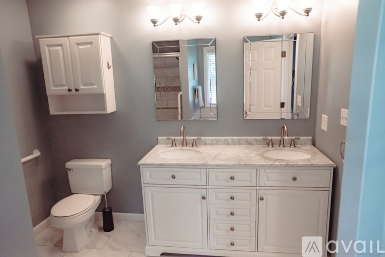 A bathroom with a toilet, sink, and mirror.