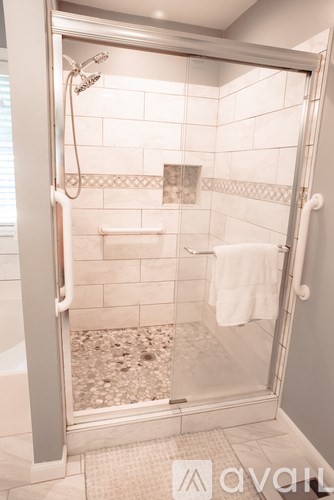 A white bathroom with a glass shower door.
