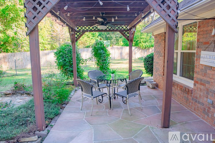A patio with a table and chairs under a pergola.