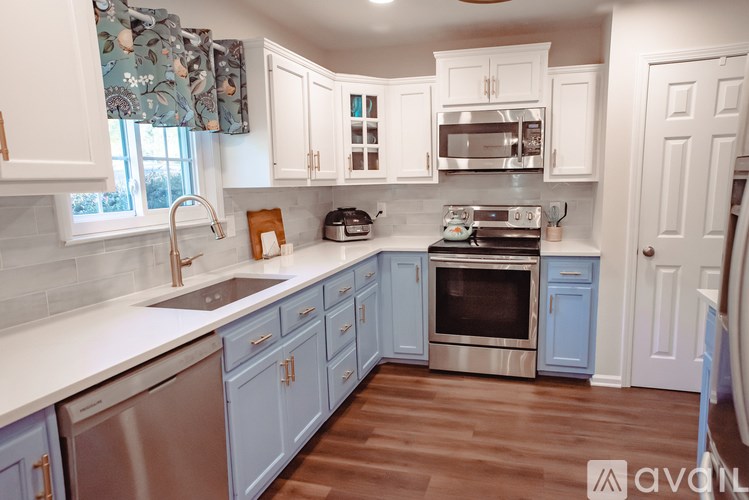 A kitchen with white cabinets and a blue backsplash.