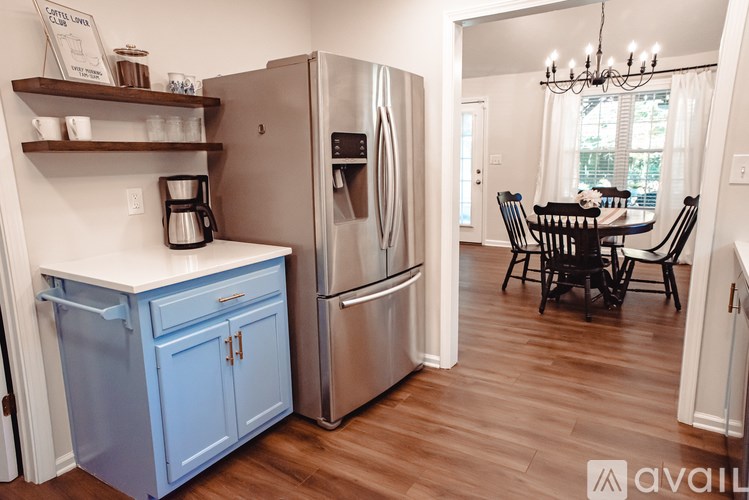 A kitchen with a blue cabinet and a silver refrigerator.