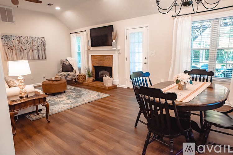 A living room with a fireplace and a dining table set up.