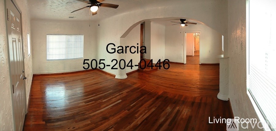 A living room with wood flooring and a ceiling fan.