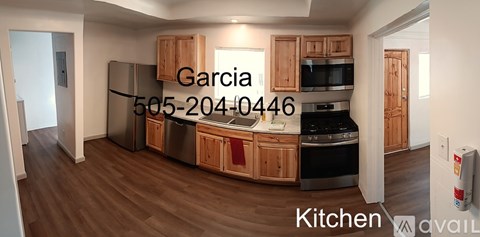 A kitchen with wooden cabinets and a refrigerator.