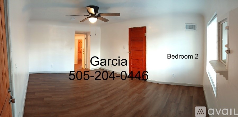 A room with a ceiling fan and a door labeled Bedroom 2.