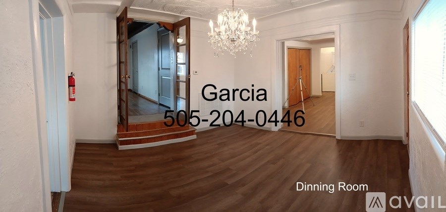 A dining room with a chandelier and a fire extinguisher on the wall.