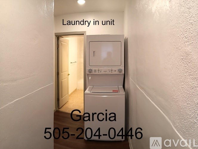 A laundry unit is located in the doorway of a hallway.
