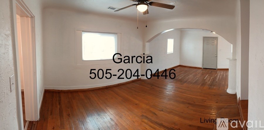 A living room with wood flooring and a ceiling fan.