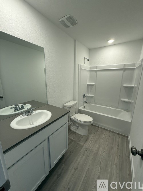 A bathroom with a sink, toilet, and bathtub.