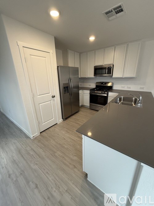 A kitchen with a black countertop and white cabinets.