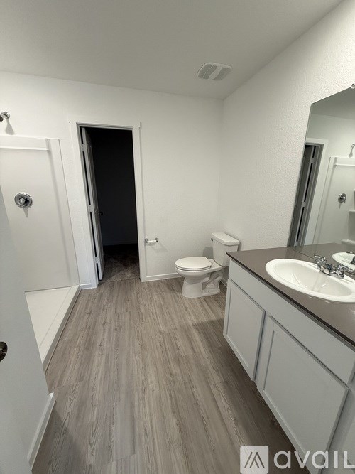 A bathroom with a toilet, sink, and mirror.