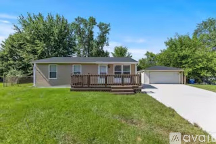 A house with a deck and a garage is for sale.