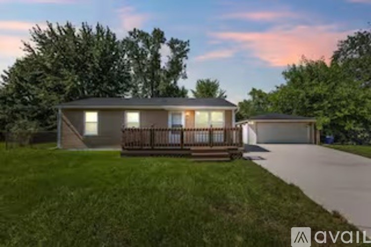 A house with a porch and a garage is available for sale.