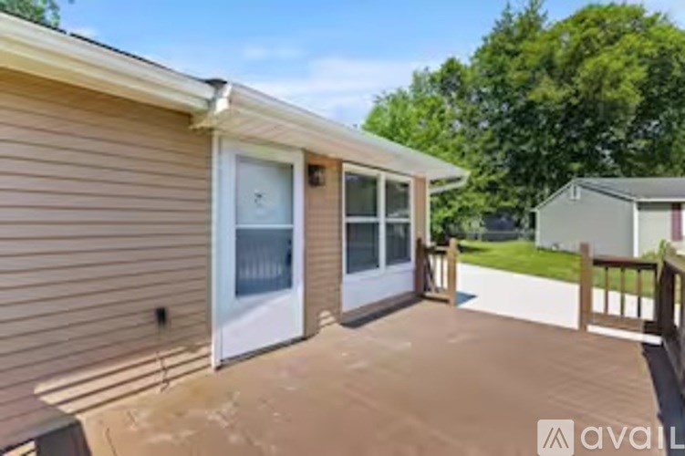 A house with a brown siding and a white door is for sale.
