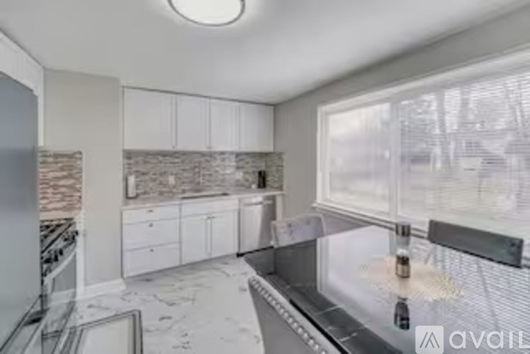 A kitchen under construction with a lot of white cabinets and a window.