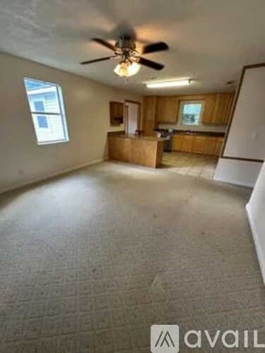 A room with a ceiling fan and a window.