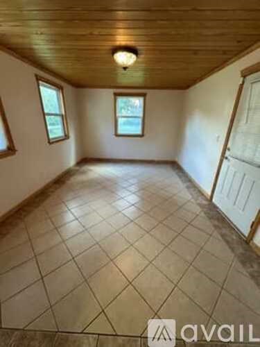 A room with a wooden ceiling and tiled floor.