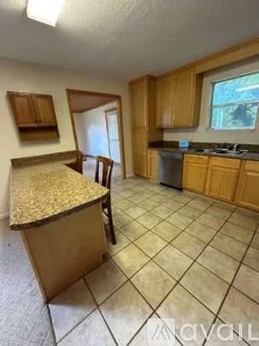 A kitchen with wooden cabinets and a granite countertop.