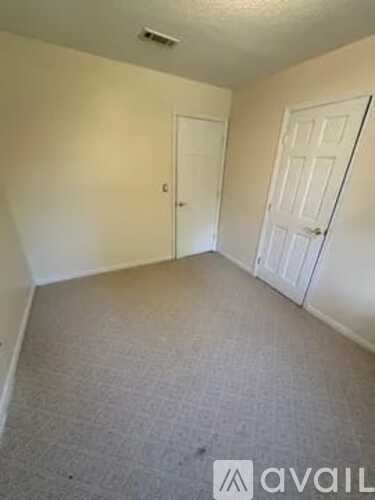 A room with two doors and a carpeted floor.