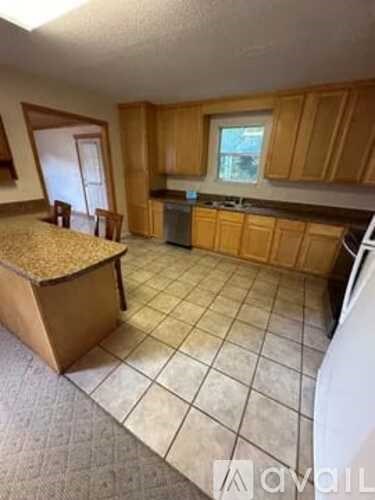 A kitchen with wooden cabinets and a tile floor.