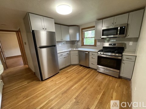A kitchen with wooden floors and stainless steel appliances.