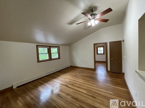 A room with wooden floors and a ceiling fan.
