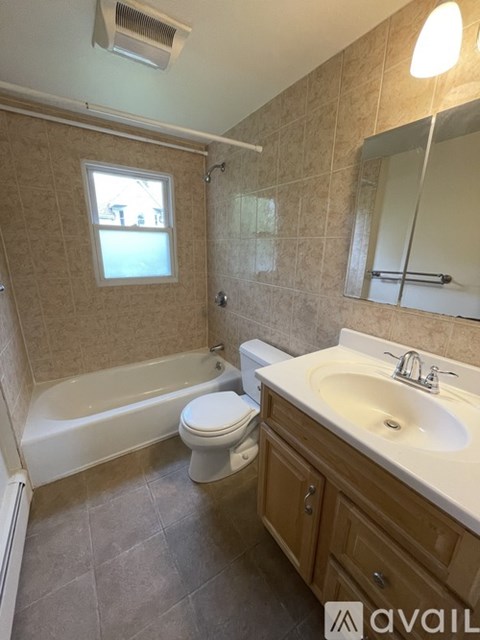 A bathroom with a toilet, sink, and bathtub.