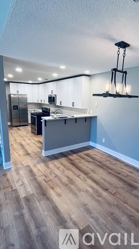 A kitchen with a refrigerator, microwave, and oven.